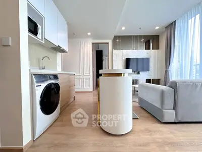 Modern open-plan living room and kitchen with sleek appliances and stylish decor