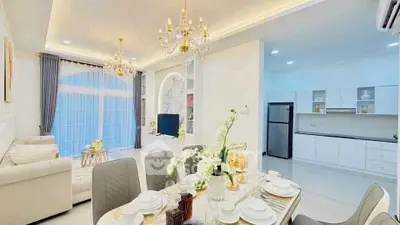 Luxurious open-plan living and dining area with elegant chandeliers and modern kitchen.