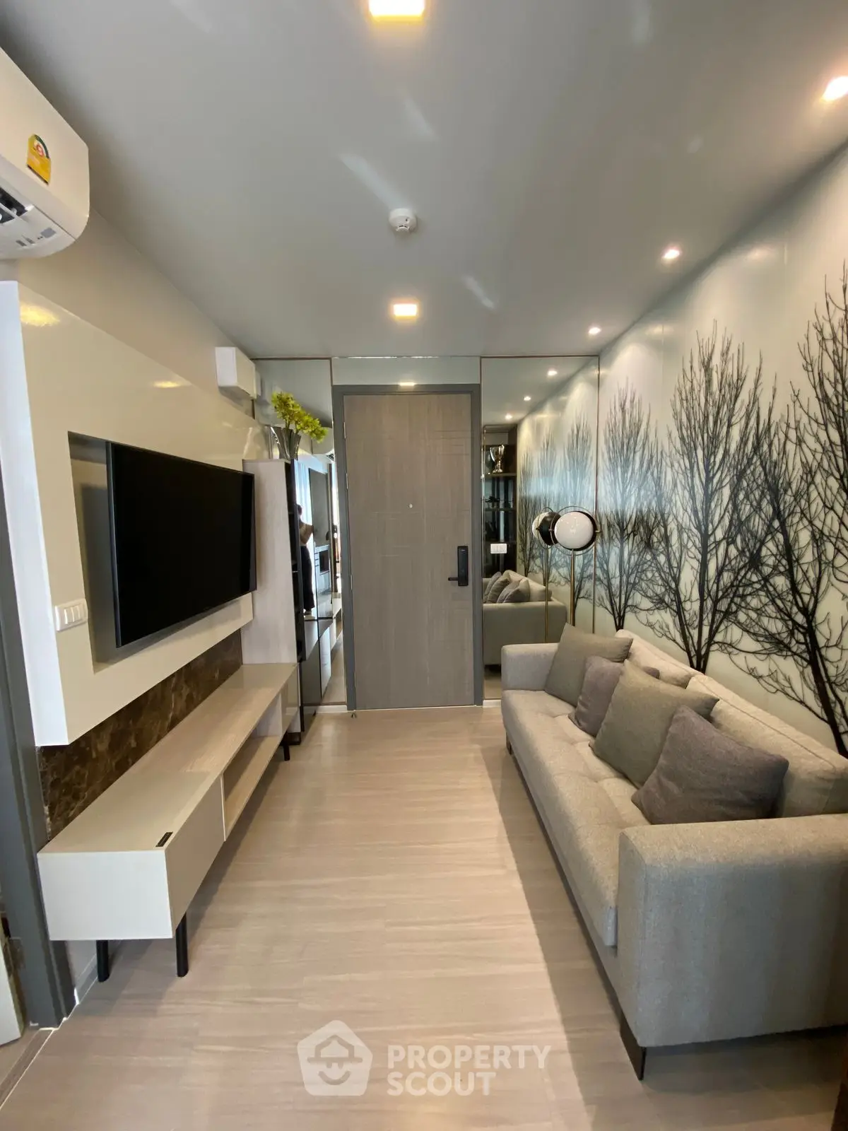 Modern living room with stylish decor and wall art, featuring a comfortable sofa and mounted TV.