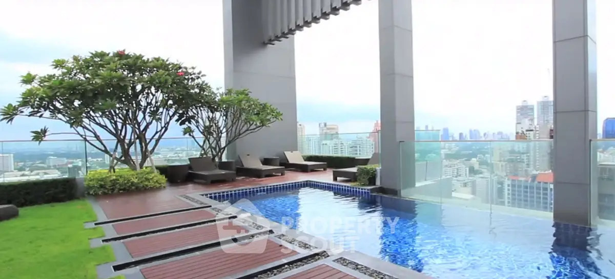 Luxurious rooftop pool with stunning city skyline view and lush greenery.