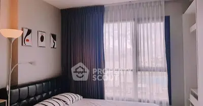 Cozy bedroom with modern decor and large window with sheer curtains