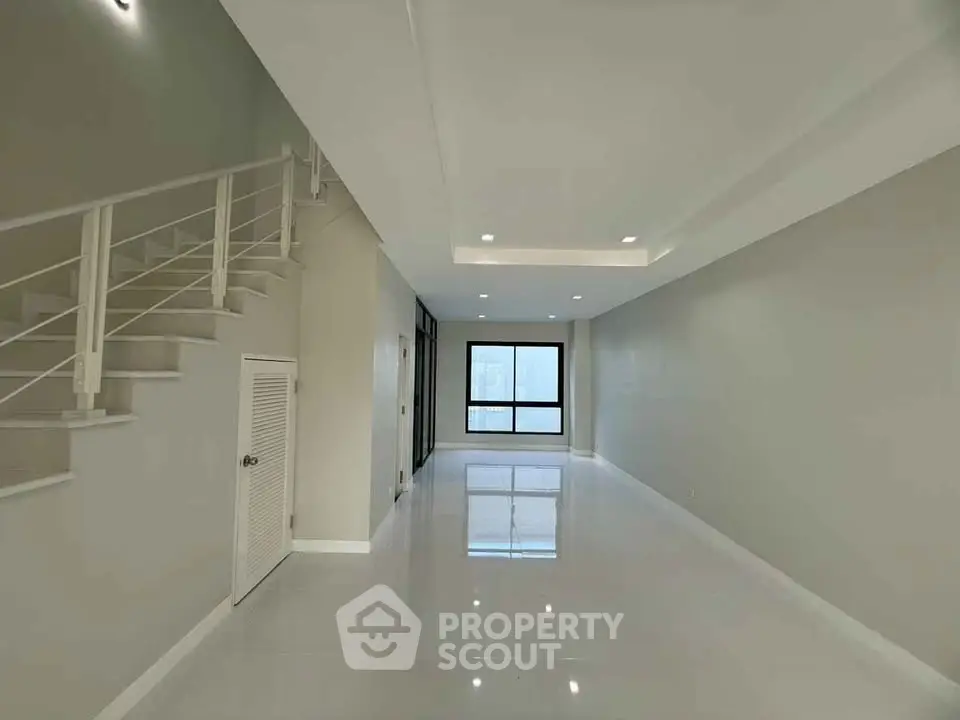 Spacious modern living room with sleek staircase and large windows