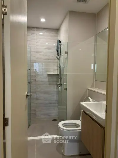 Modern bathroom with sleek design, featuring glass shower and contemporary fixtures.
