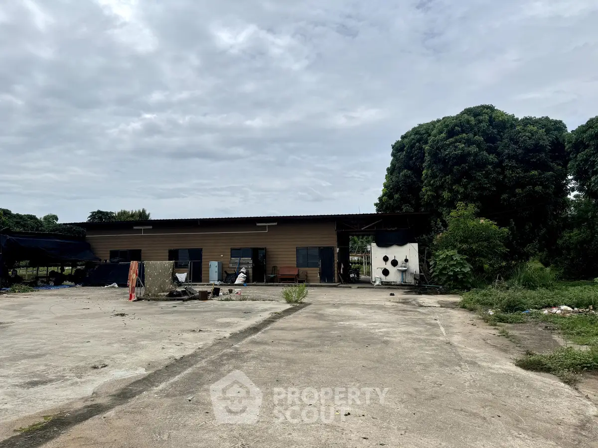 Spacious industrial property with ample outdoor space and greenery, ideal for commercial use.