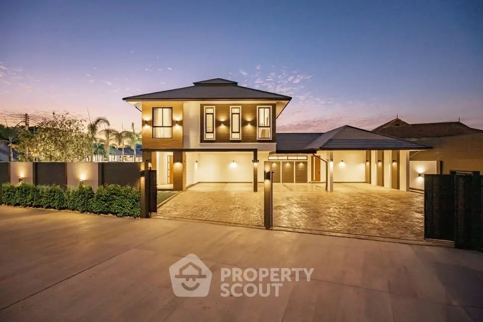 Stunning modern two-story home with elegant lighting and spacious driveway at dusk.