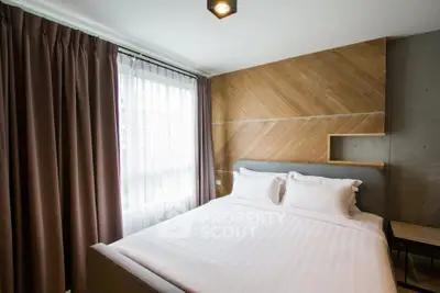 Modern bedroom with stylish wood paneling and large window for natural light.