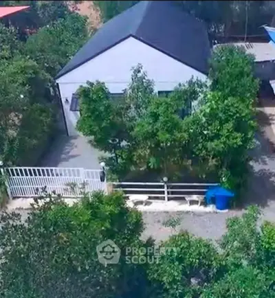 Charming suburban house with lush greenery and gated entrance, perfect for serene living.
