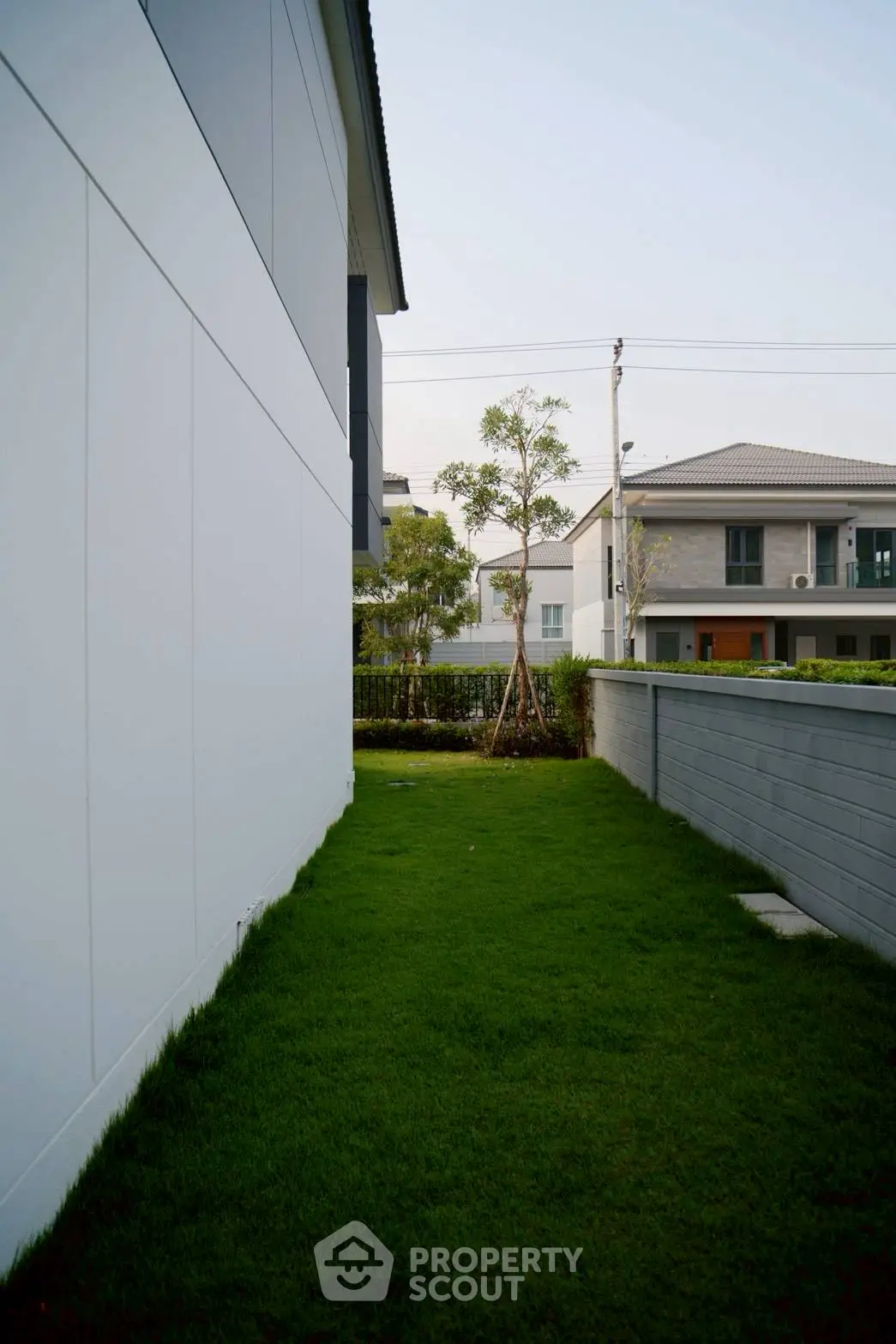 Modern suburban house with lush green lawn and sleek exterior design.