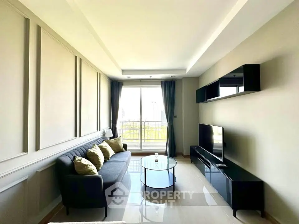 Modern living room with sleek furniture and large window offering natural light