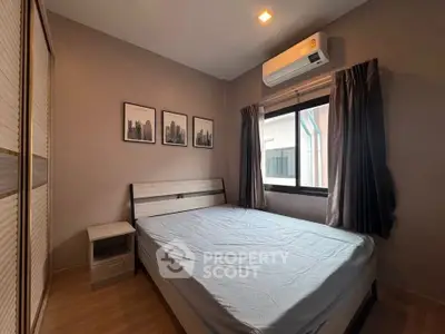 Cozy bedroom with modern decor and natural light, featuring a comfortable bed and stylish artwork.