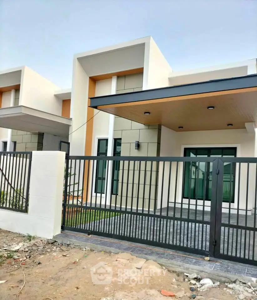Modern minimalist house exterior with sleek design and gated entrance, perfect for contemporary living.