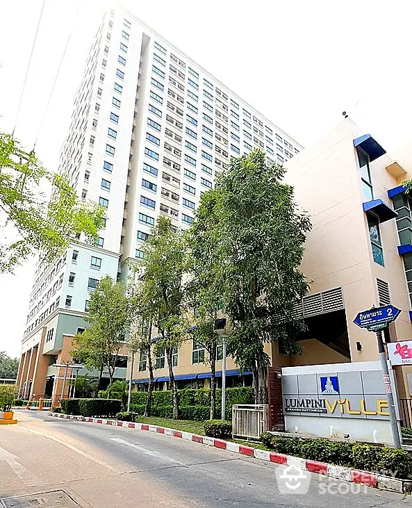 Modern high-rise condominium with lush greenery and secure entrance