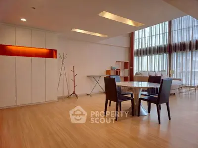 Spacious modern living room with elegant dining area and natural light.