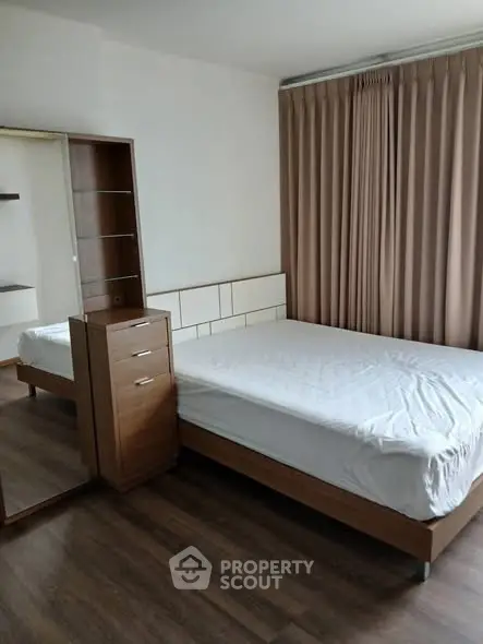 Cozy bedroom with wooden furniture and large window curtains