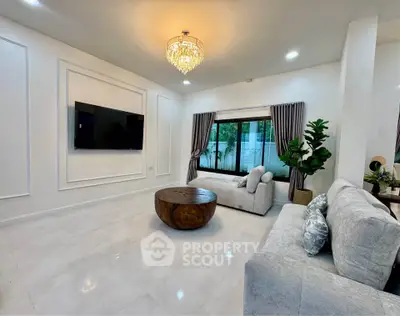 Elegant living room with chandelier, modern furniture, and large window view.
