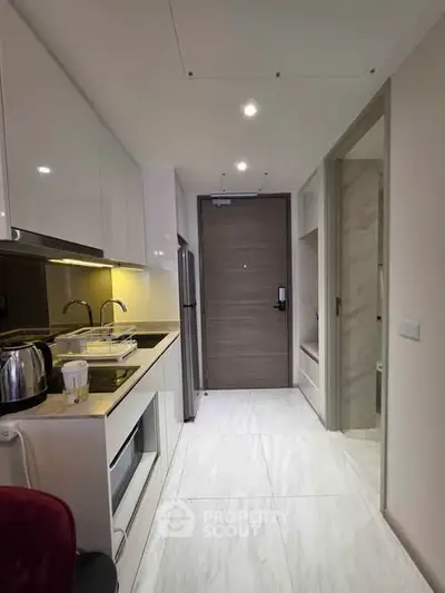 Modern kitchen with sleek appliances and minimalist design in a contemporary apartment.