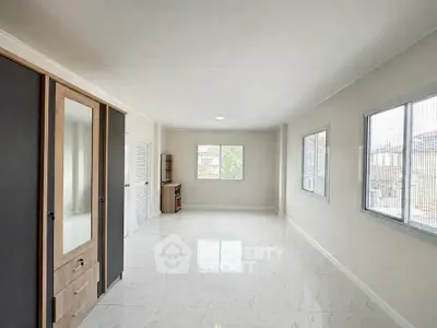 Spacious and bright empty room with large windows and modern wardrobe