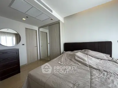 Spacious bedroom with modern decor and mirrored wardrobe in a stylish apartment.