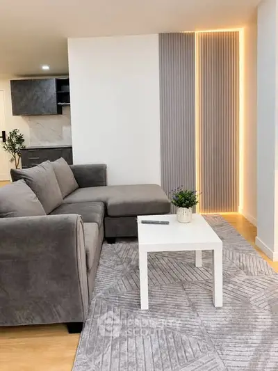 Modern living room with stylish gray sofa and elegant lighting