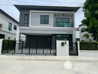 Modern two-story house with sleek design and spacious driveway in a suburban neighborhood.