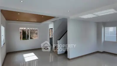 Spacious modern living room with natural light and elegant staircase