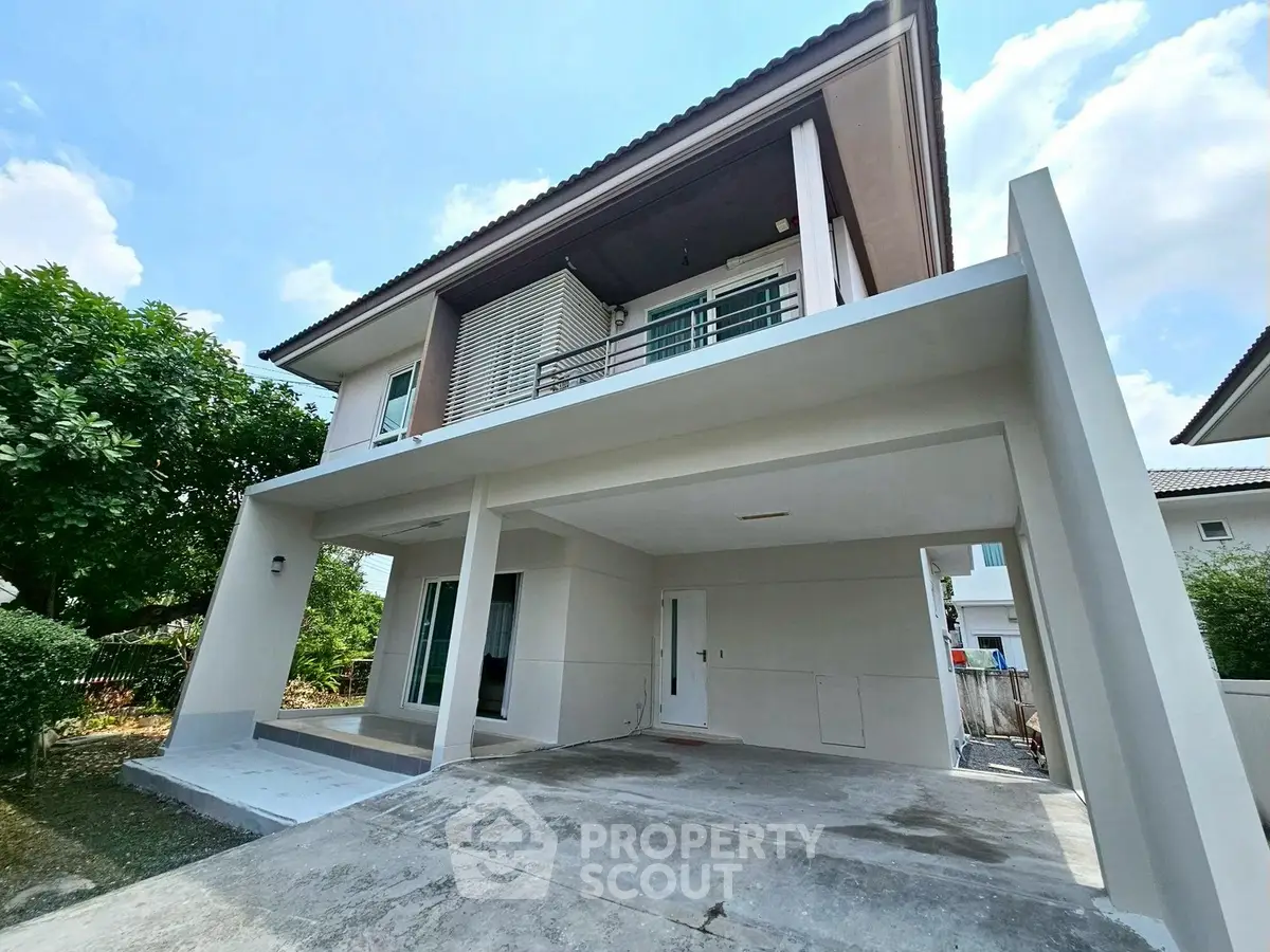 Modern two-story house with spacious driveway and lush greenery