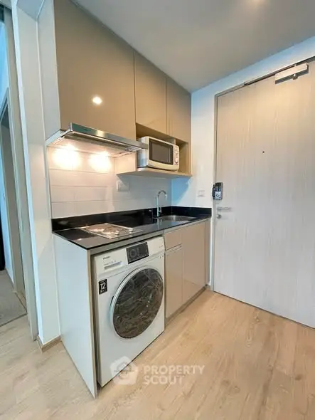 Modern compact kitchen with integrated appliances and sleek cabinetry