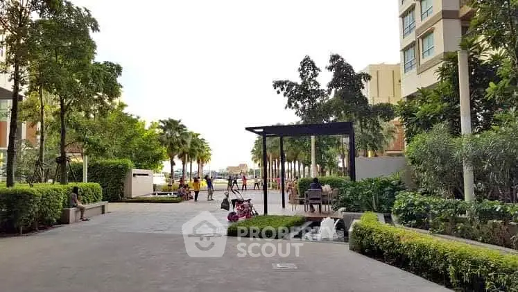 Beautiful garden area with lush greenery and modern architecture in a residential complex.