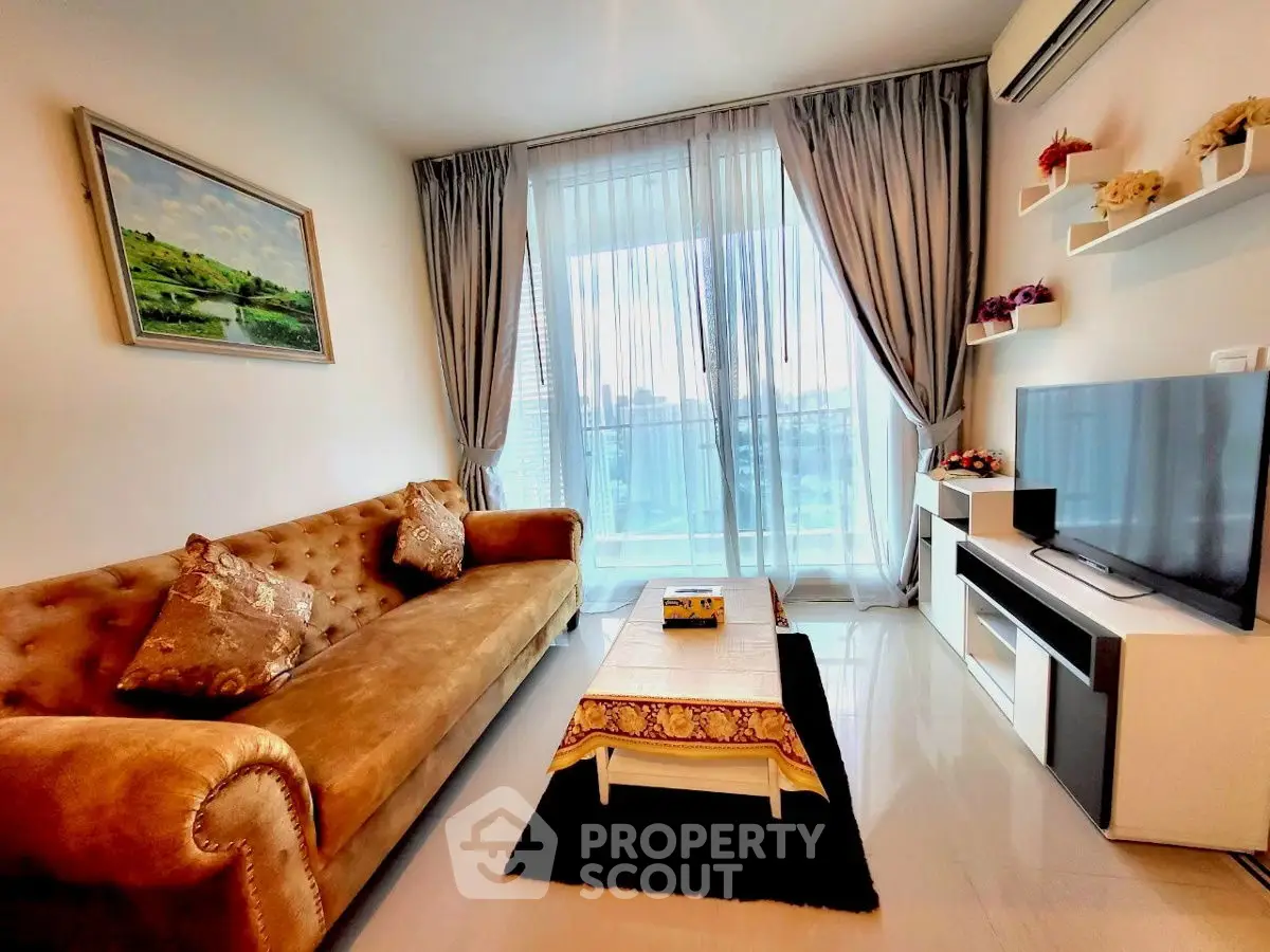 Elegant living room with plush sofa, modern TV unit, and city view balcony.