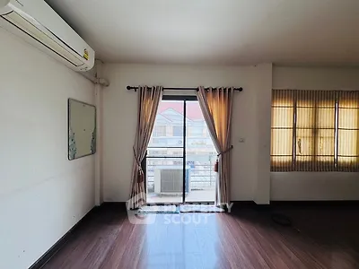 Spacious room with large window and air conditioning, ideal for comfortable living.