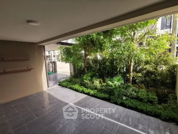 Spacious covered patio with lush garden view and modern tiled flooring.