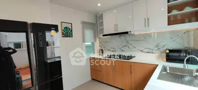 Modern kitchen with sleek cabinets, marble backsplash, and stainless steel appliances.