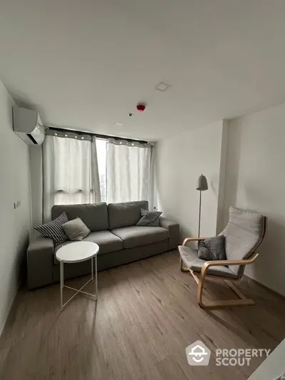 Modern living room with cozy sofa and armchair, minimalist design, bright natural light.