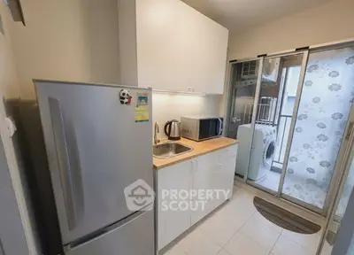 Compact kitchen with modern appliances and balcony view