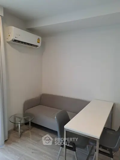 Modern compact living room with sleek furniture and air conditioning, perfect for urban living.