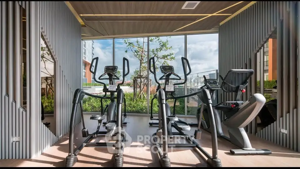 Modern gym with state-of-the-art exercise equipment and large windows offering a scenic view.