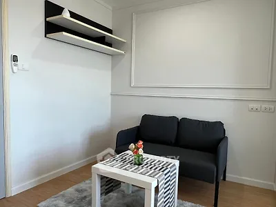 Modern living room with sleek black sofa, stylish shelves, and chic coffee table in a cozy apartment.