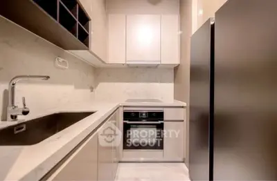 Modern kitchen with sleek cabinetry and built-in oven in a compact layout.