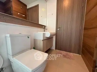 Modern bathroom with sleek fixtures and wooden accents, perfect for a contemporary home.