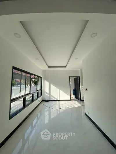 Bright and spacious room with large windows and modern ceiling design, perfect for natural light lovers.