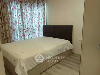 Cozy bedroom with floral curtains and modern decor, perfect for relaxation.