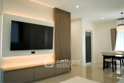 Modern living room with sleek TV setup and elegant dining area, perfect for contemporary living.