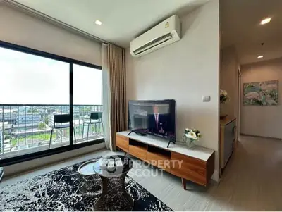 Modern living room with large window and stylish furniture, offering a bright and inviting atmosphere.