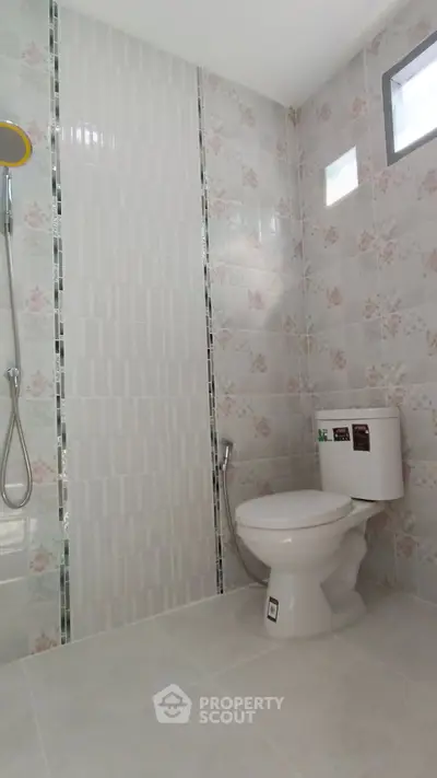Modern bathroom with floral tiles and shower area
