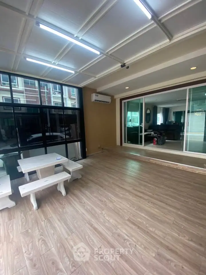 Spacious interior with wooden flooring and large windows, perfect for modern living.