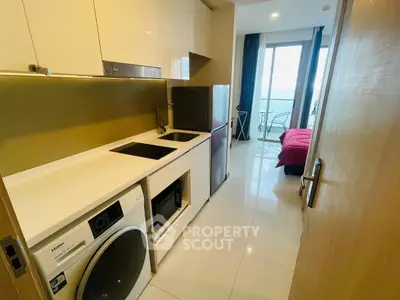 Modern compact kitchen with appliances and view into a cozy bedroom