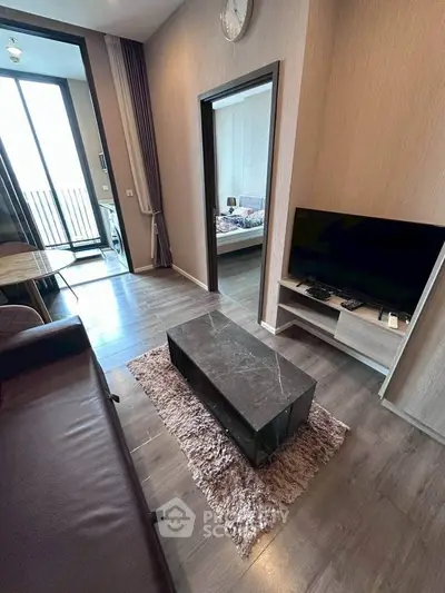 Modern living room with sleek furniture and balcony view in a stylish apartment.