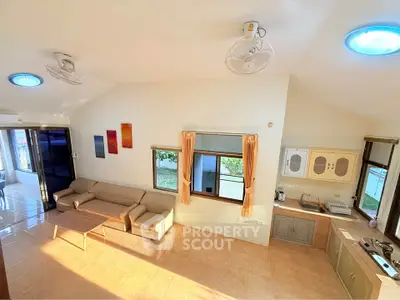 Spacious living room with natural light and modern kitchen in open layout