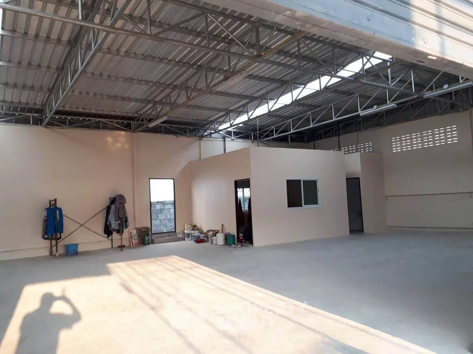 Spacious industrial-style warehouse with high ceiling and ample storage space.