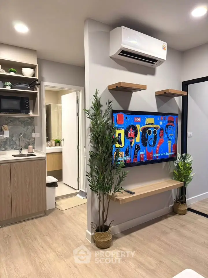 Modern living room with stylish decor, open kitchen, and vibrant wall art in a cozy apartment.